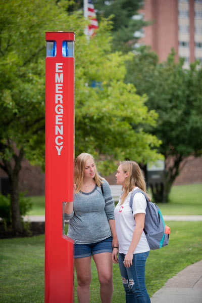 Two students standing beside a new blue lite phone